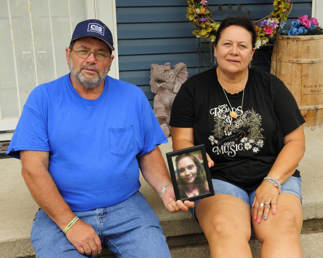 Hailey Christiansen's mom and dad, Janet and Mike, show a photo of Hailey while sitting on the front porch of their home. They have a statue of an elephant in the background - Hailey loved elephants ever since she was a little girl.