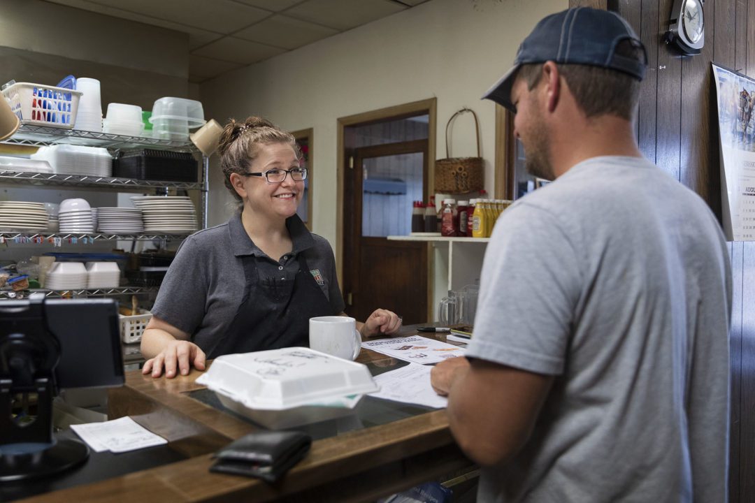 Owner Dawn Witchell, left, talks with customer Daryl Guthard as he picks up a take out order.