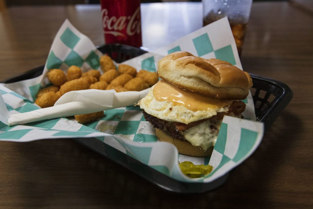 This is the Sriracha burger with a side of cheese balls made at the City Cafe. The spicy burger served with a fried egg on top is a favorite of customers.