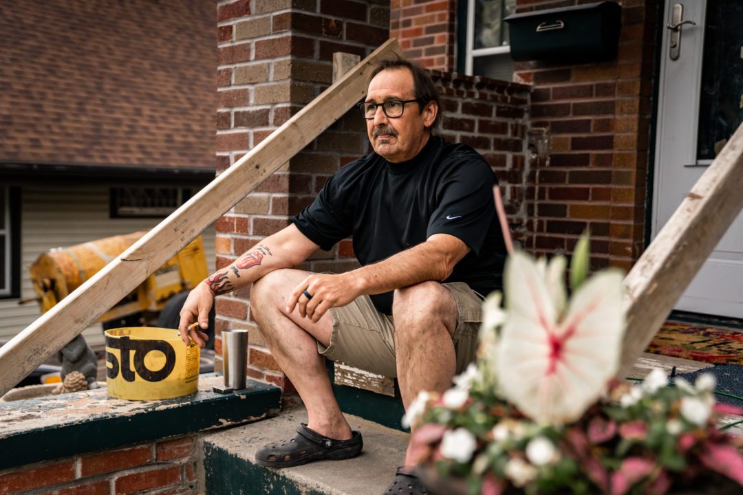 Kerry Blacketer sits on the porch of the North Omaha rental home where he and wife Vicky Blacketer have lived for nearly 16 years. Photo by Abiola Kosoko for the Flatwater Free Press