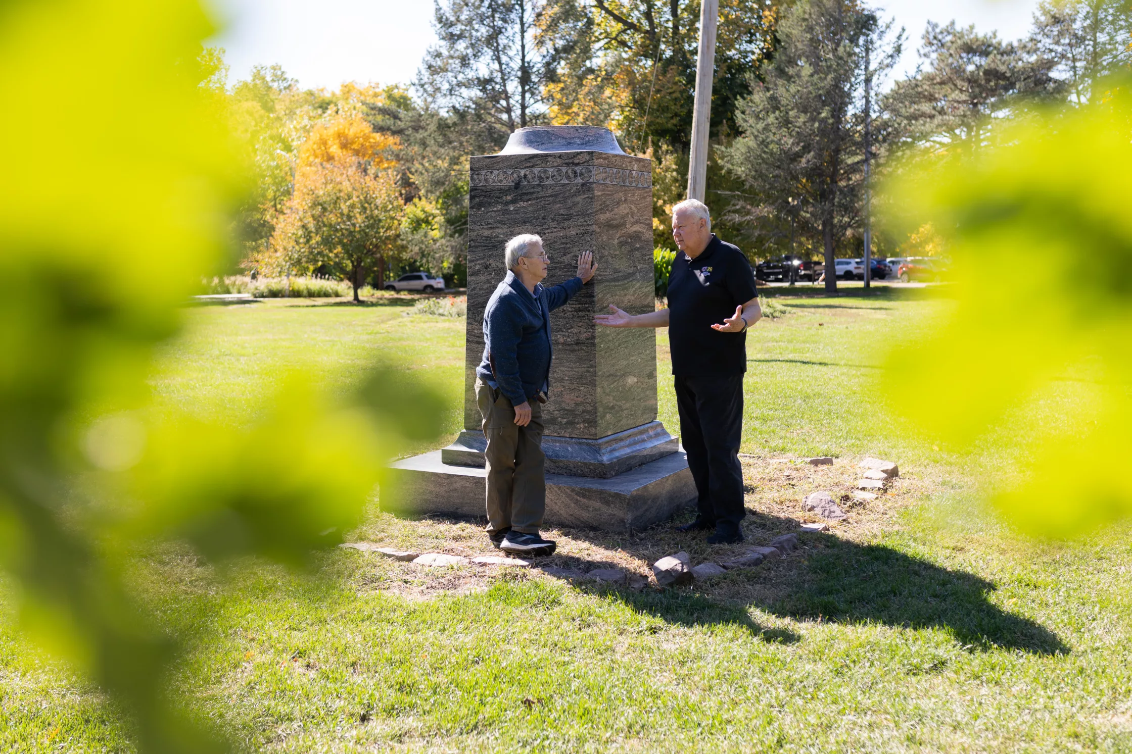 Former Dundee-Memorial Park Association president B.J. Reed (right) and association historian Jim McGee talk at the pedestal where Bosco, aka Mr. Strikeout, once stood in Elmwood Park. Photo by Joseph Saaid for the Flatwater Free Press