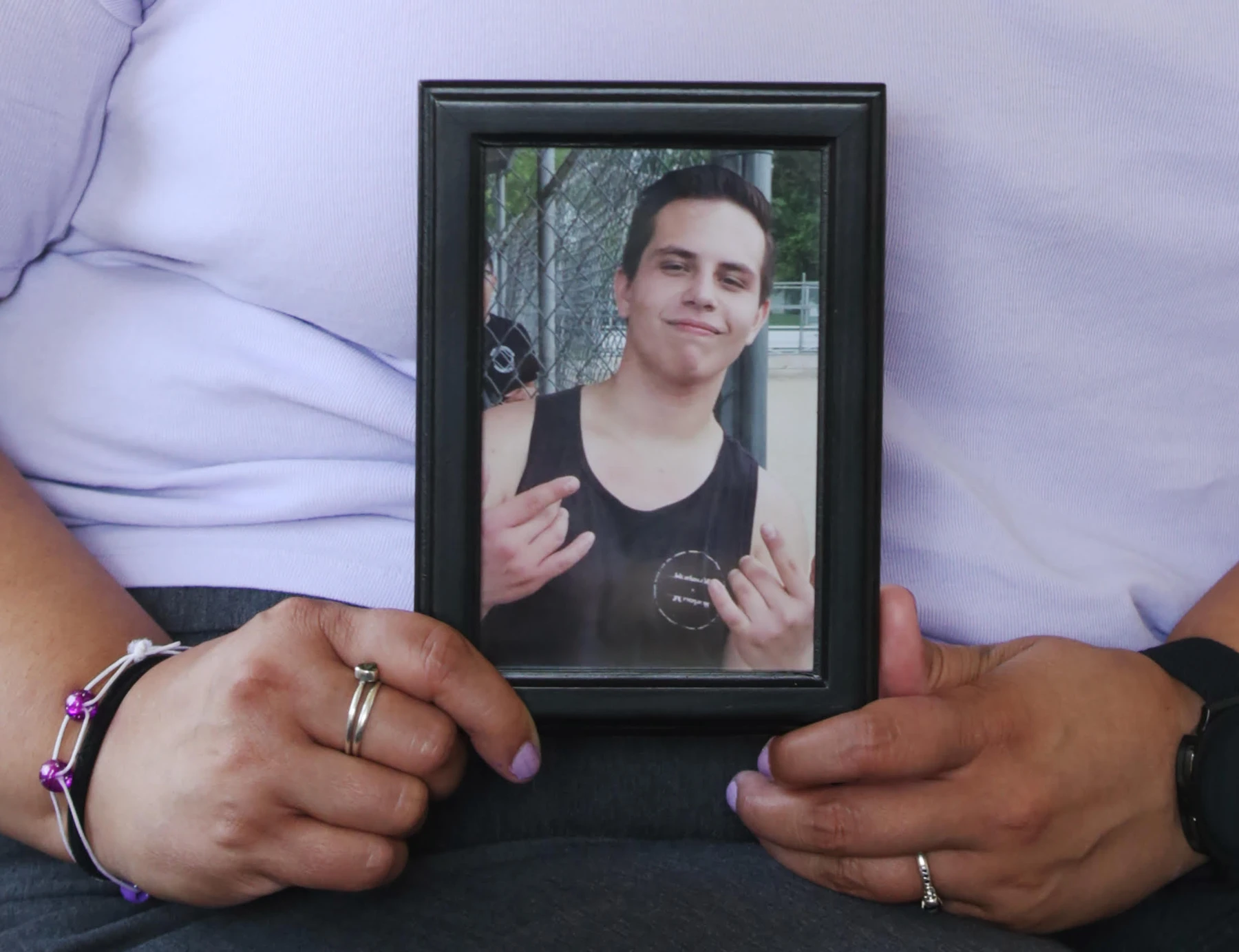 Lindsey Lyons, a counselor at Revive Inc. in Hastings, holds a photo of her brother Derrek Cocchiarella.